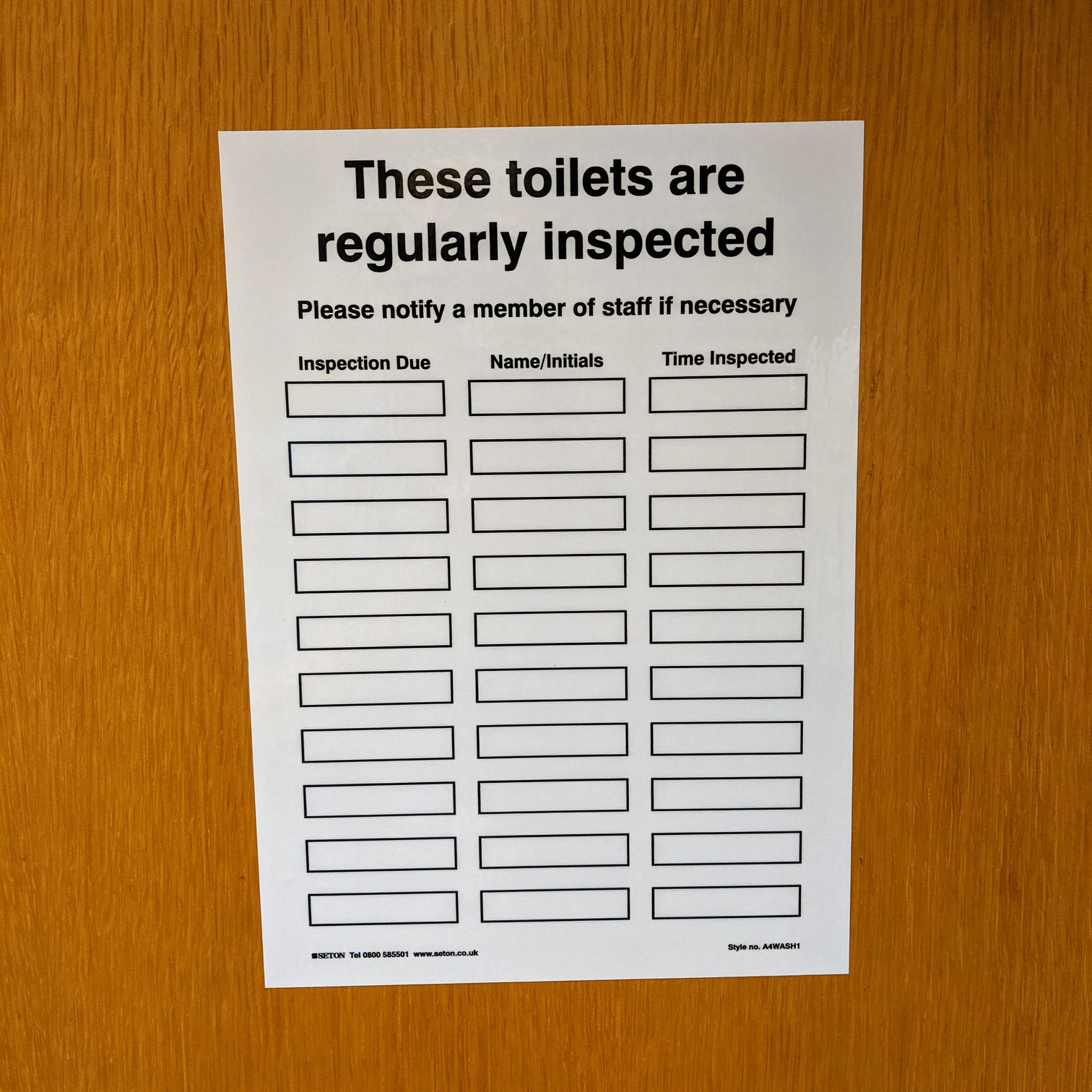 Sign on a toilet door saying "These toilets are regularly inspected"