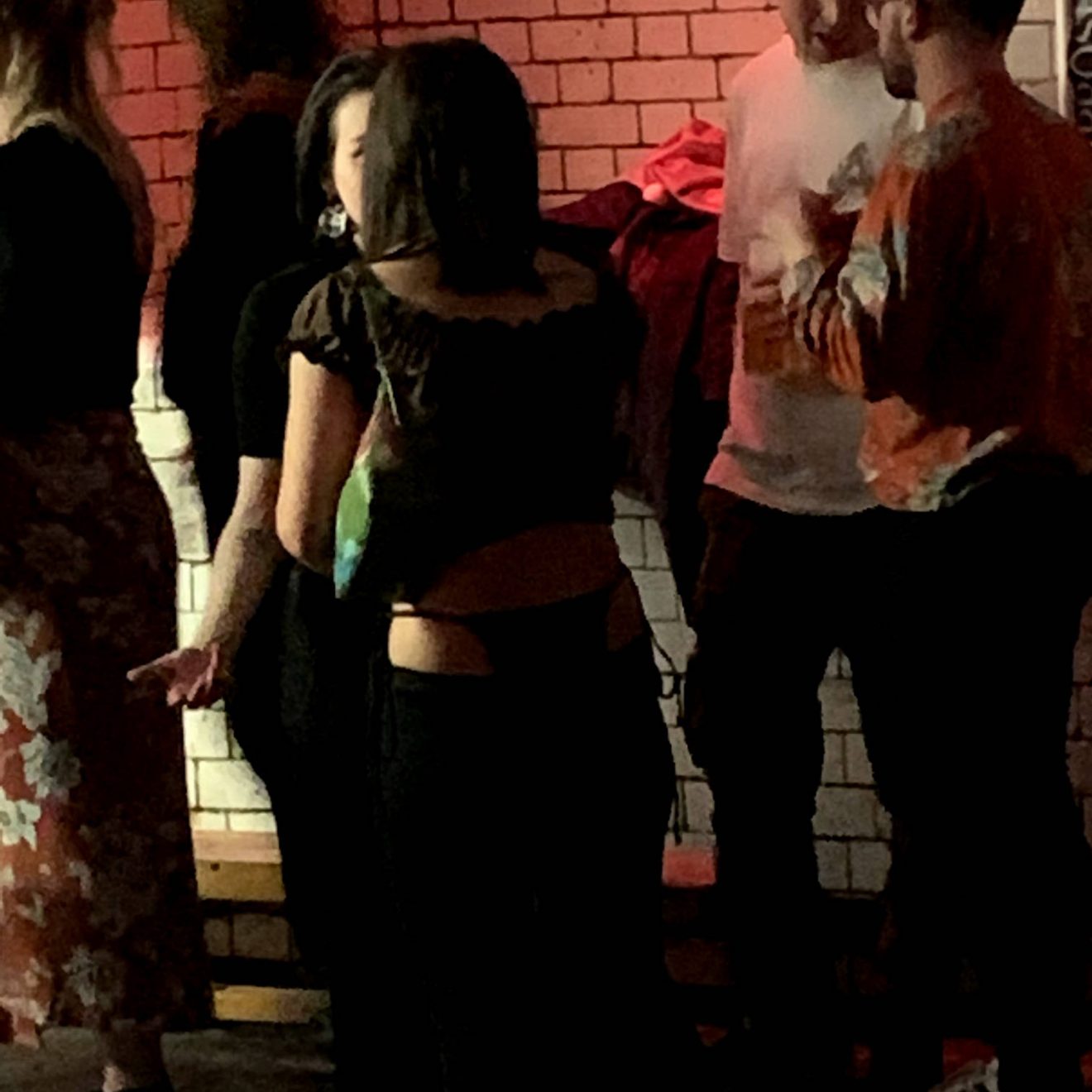 A nightclubber with a thong sticking way too high out of their trousers