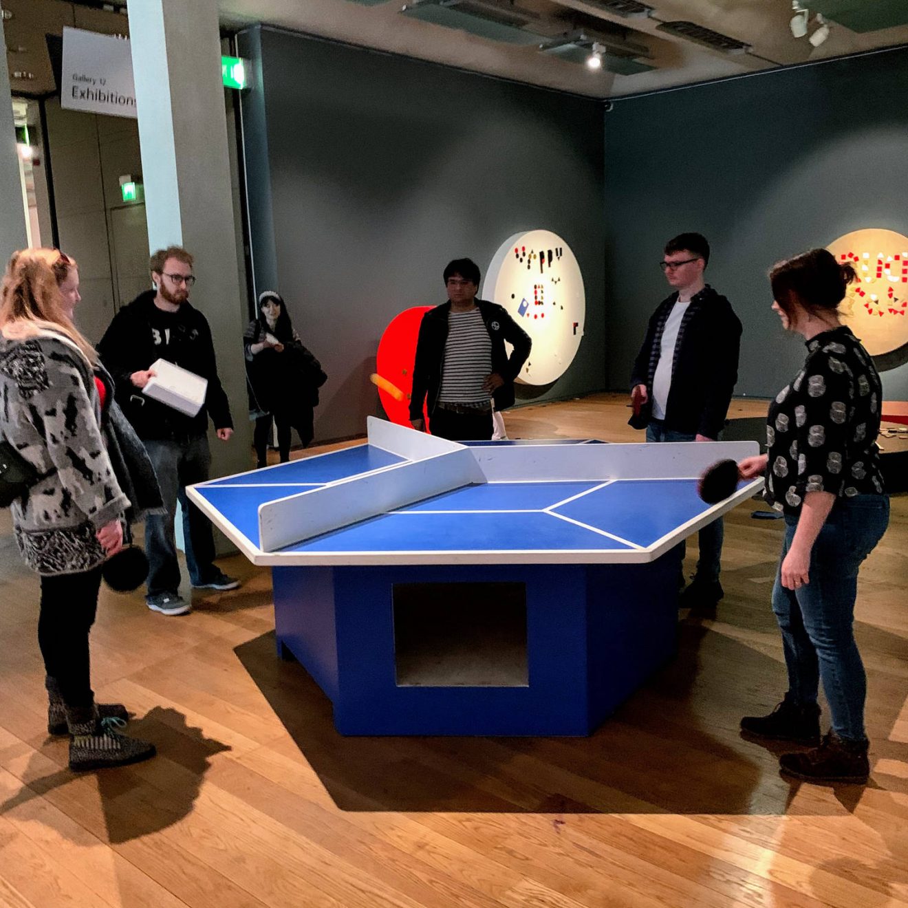 All of us playing at a hexagonal table tennis table