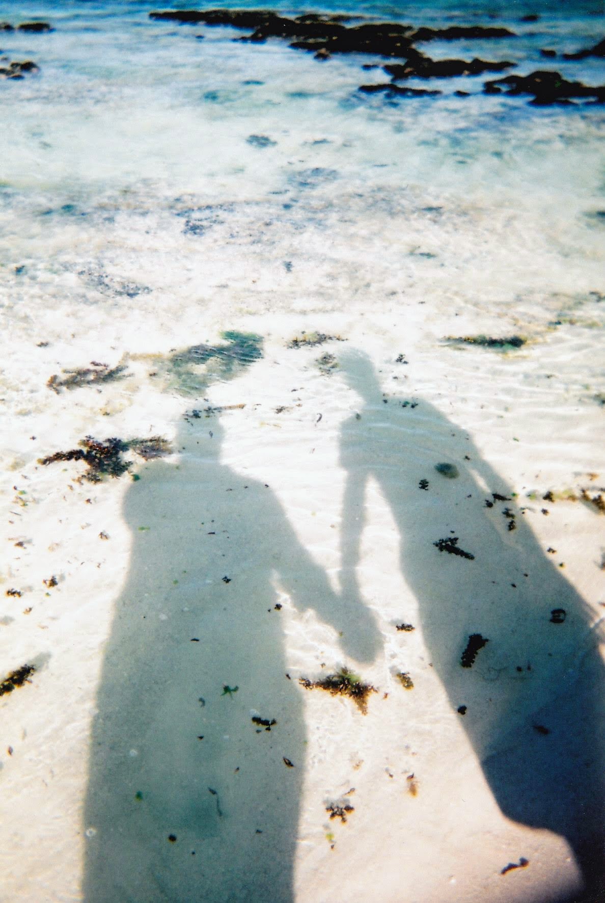 Shadows of Alex and me holding hands on the beach (taken on the disposable camera)