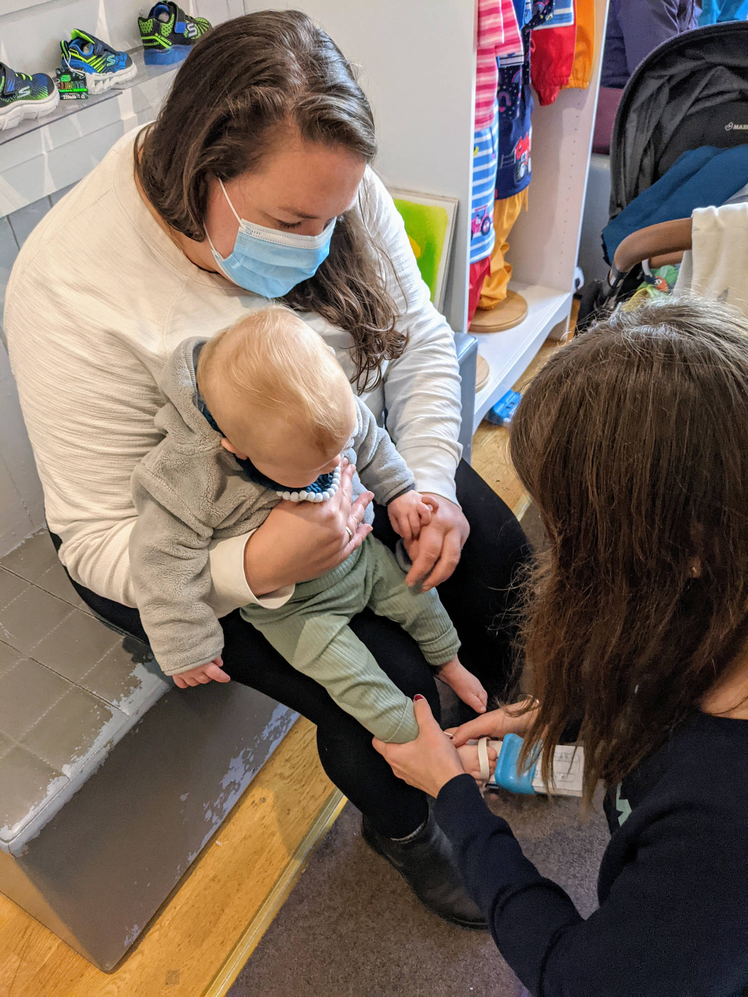 Alex holding Izzy while she gets her feet measured