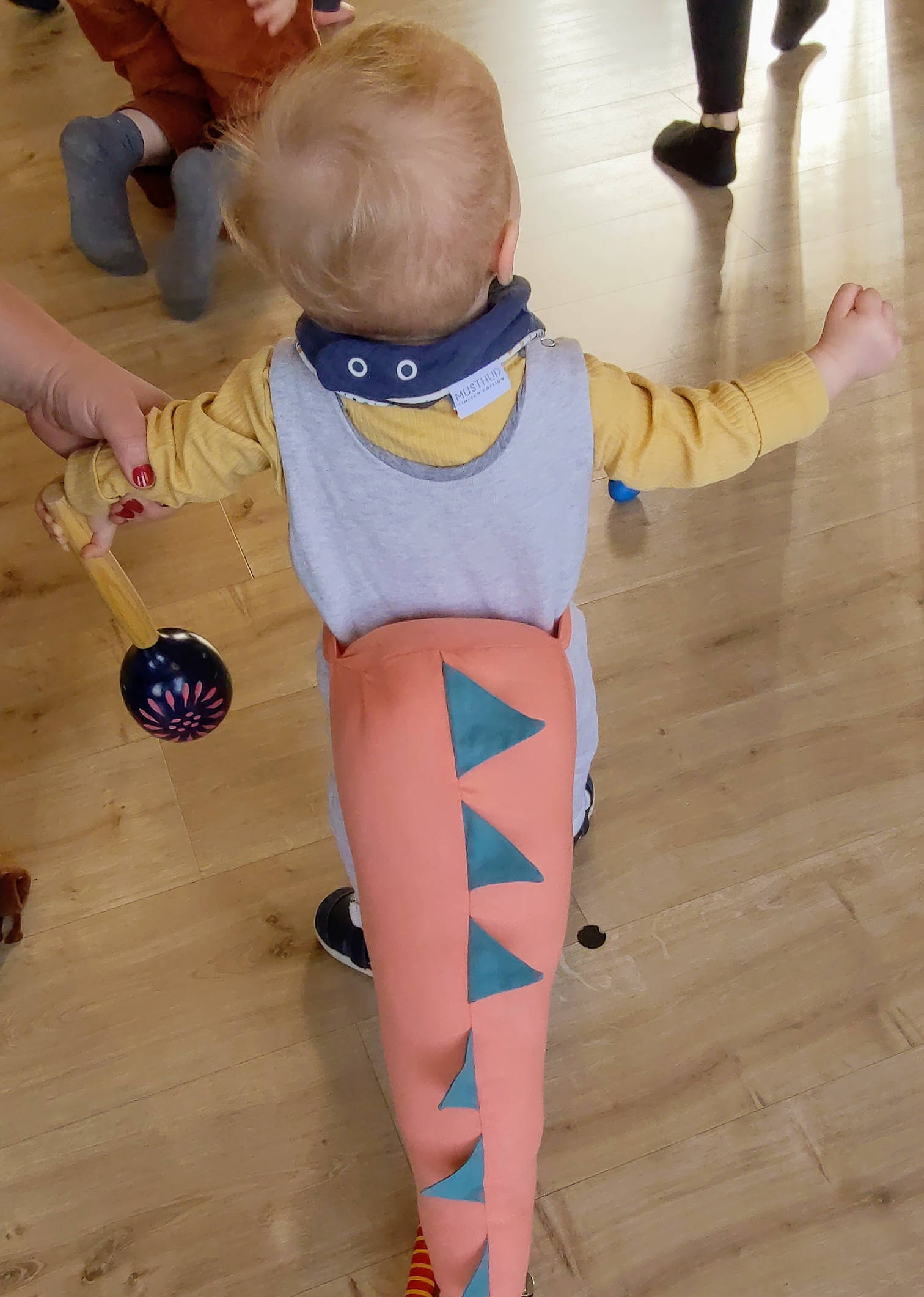 Izzy wearing a dinosaur tail