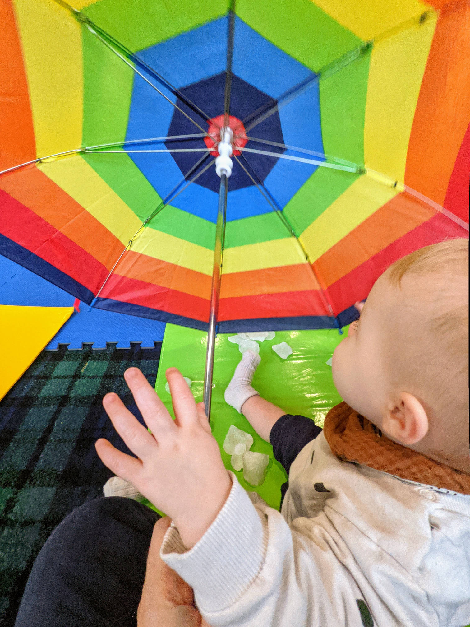Izzy looking at a balloon with rainbow colours